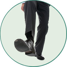 Imagem de baixo para cima de um homem com sapato e calça social preta.